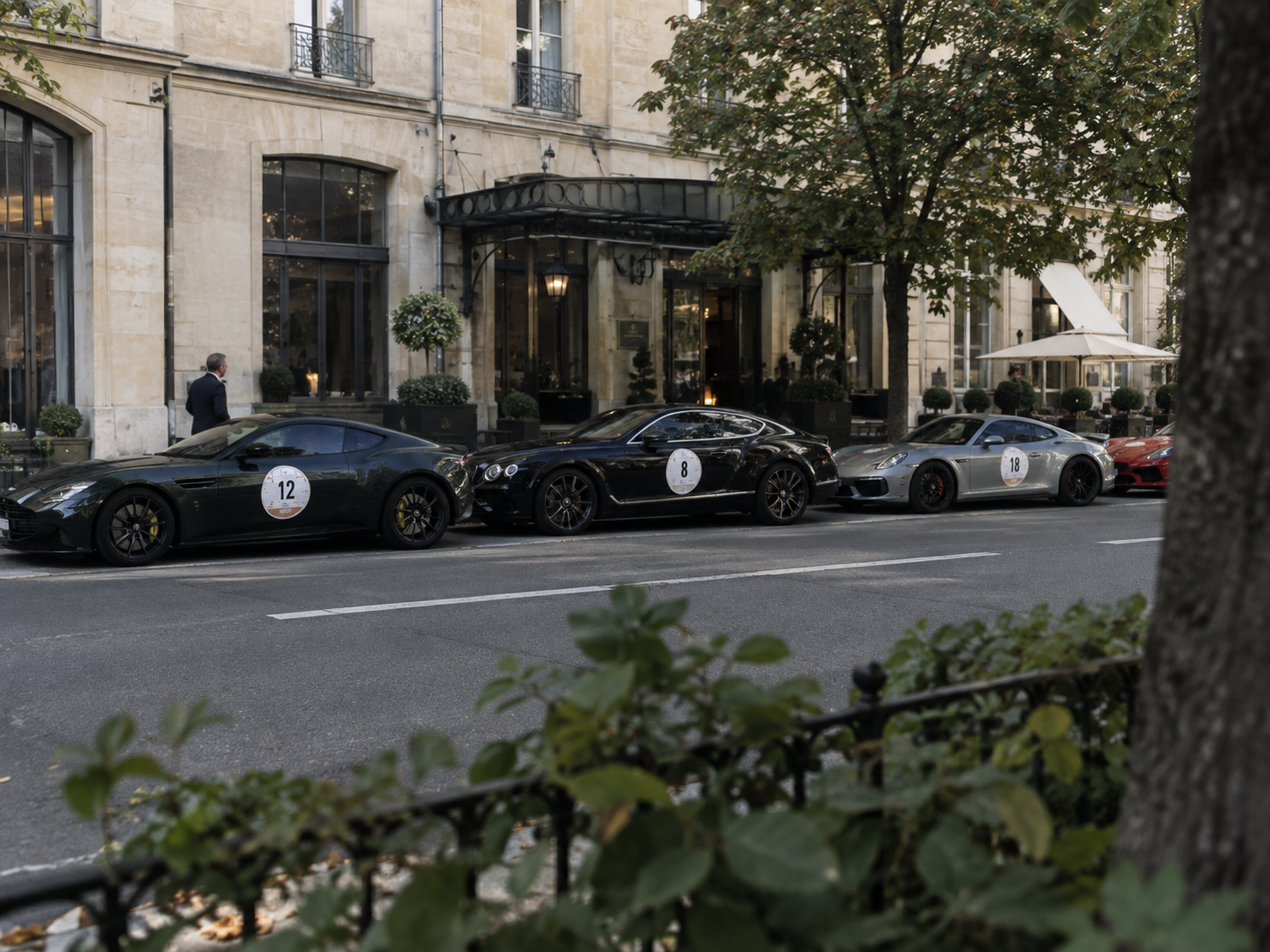 Rallye automobile de prestige devant un établissement hôtelier